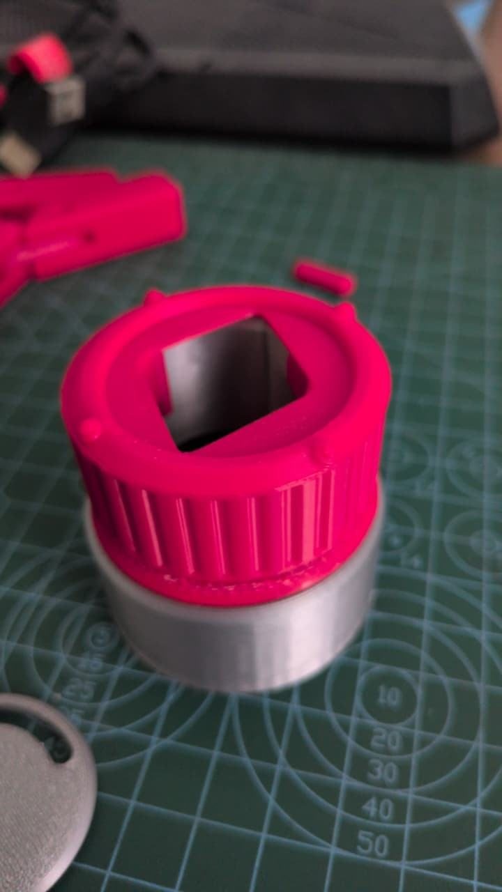 A pink printed dial cap with a square opening on the silver body