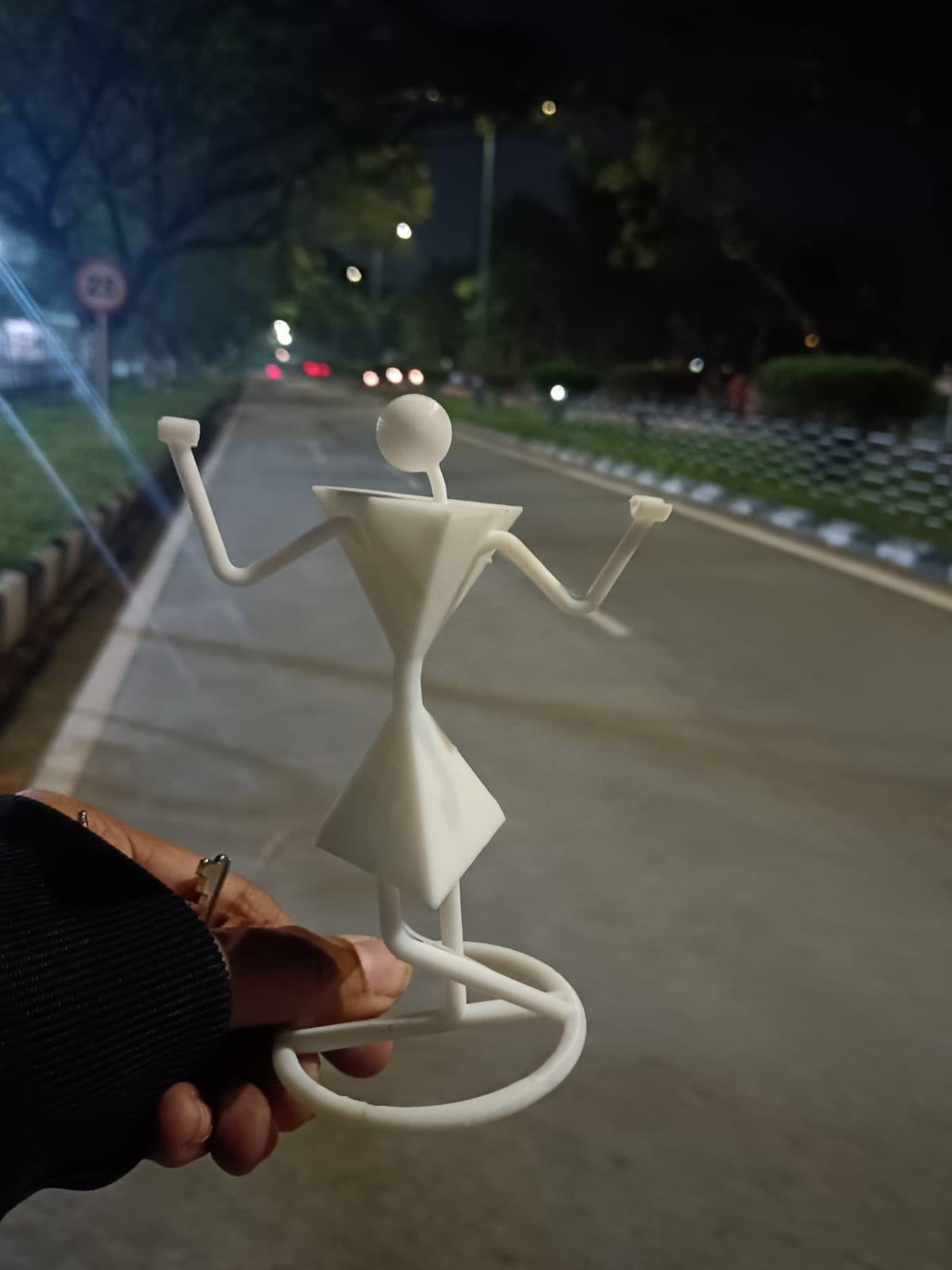 The finished key holder held in a hand on a road at night